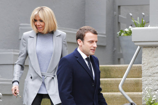 Centrist candidate Emmanuel Macron and his wife Brigitte leave their house before voting in the first round of the French presidential election