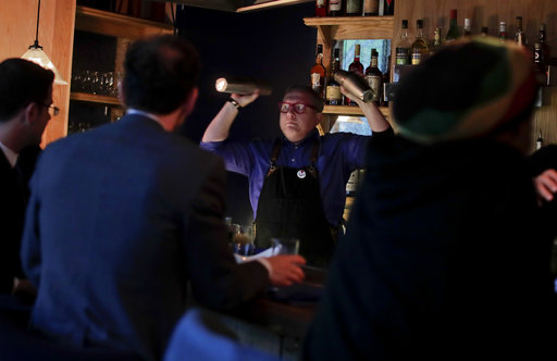 Coup co-founder Sother Teague mixes drinks for customers shortly after opening the bar