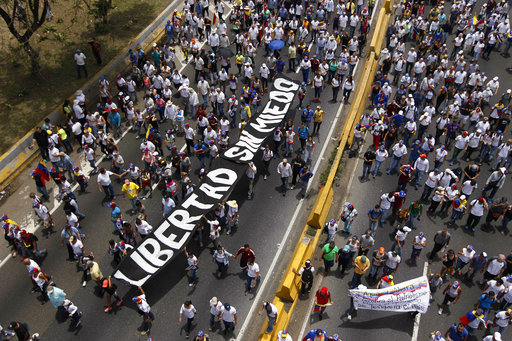 Anti-government protesters march with a banner that reads in Spanish "Freedom without fear" along a highway in Caracas