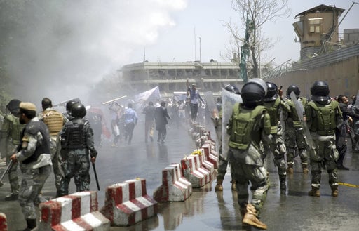 Police forces run as protesters throw stones during a demonstration in Kabul