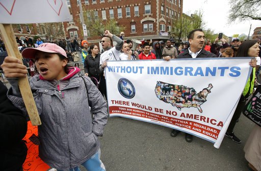 Demonstrators display placards and chant slogans during a May Day rally