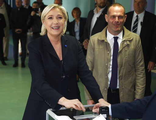 Far-right leader and candidate for the 2017 French presidential election Marine Le Pen casts her vote for the first-round presidential election while her partner Louis Aliot looks on