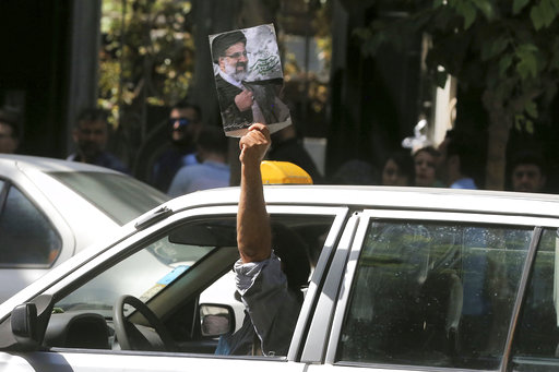 A supporter holds a poster of Iranian presidential candidate cleric Ebrahim Raisi