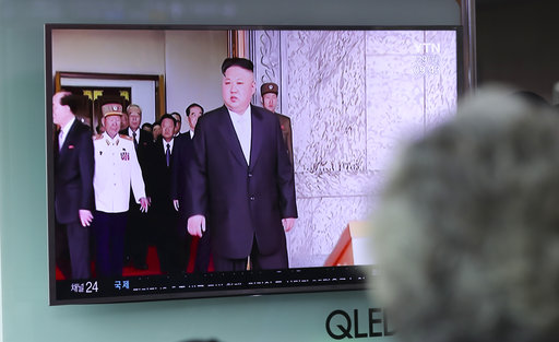 A woman watches a TV screen showing a file footage of North Korean leader Kim Jong Un