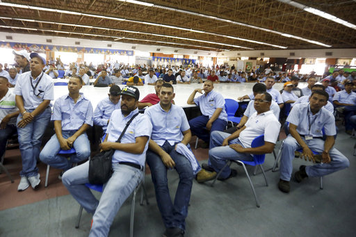 Workers of General Motors listen during a meeting with government officials at the company's plant in Valencia