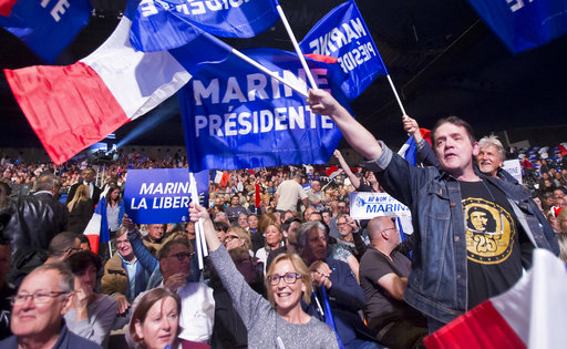 Supporters of far-right leader and candidate for the 2017 French presidential election Marine Le Pen waves flags during a meeting in Marseille