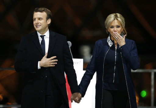 French President-elect Emmanuel Macron holds hands with his wife Brigitte during a victory celebration outside the Louvre museum in Paris