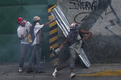 An anti-government protesters throws a molotov bomb at security forces in Caracas
