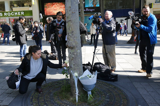 A woman lays a flower at the place of Thursday's attack on the Champs Elysees boulevard in Paris