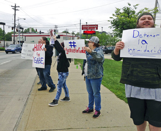 Parents and other demonstrators hold signs against bullying and in memory of Gabriel Taye