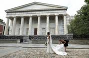 A photographer adjusts Yifat Ayalon's wedding dress as she has photos taken in front of the Second Bank of the United States