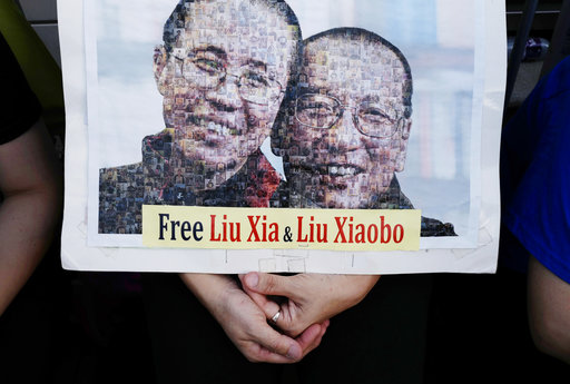 Protesters display a portrait of jailed Chinese Nobel Peace laureate Liu Xiaobo and his detained wife Liu Xia during a demonstration outside the Chinese liaison office in Hong Kong