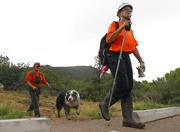 Members of the Tonto Rim Search and Rescue team exit a section of forest after searching along the banks of the East Verde River for victims of a flash flood