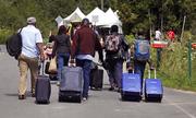 A family from Haiti approach a tent in Saint-Bernard-de-Lacolle