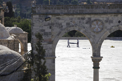Israeli police forensic experts carry the body of a Palestinian at the scene of an attack in the Al Aqsa Mosque compound in Jerusalem's Old City