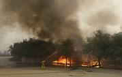 A firefighter sprays a Keysight Technologies building in Santa Rosa