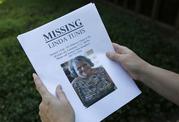 Jessica Tunis stands outside a Red Cross evacuation center and holds a flyer about her missing mother Wednesday