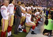 Members of the San Francisco 49ers kneel during the playing of the national anthem before an NFL football game against the Indianapolis Colts