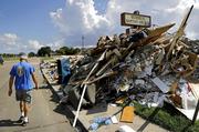 Wayne Christopher walks by a pile of debris outside the church he'd attended his whole life damaged from Hurricane Harvey in Port Arthur