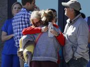 Two women embrace outside of a family assistance center Monday