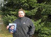Marie Eugair poses with a photograph of her late adopted brother John Paul Greene-Eugair in Pittsford