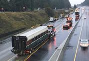 An Amtrak train car that careened off an overpass south of Seattle is hauled away on Interstate 5 Tuesday
