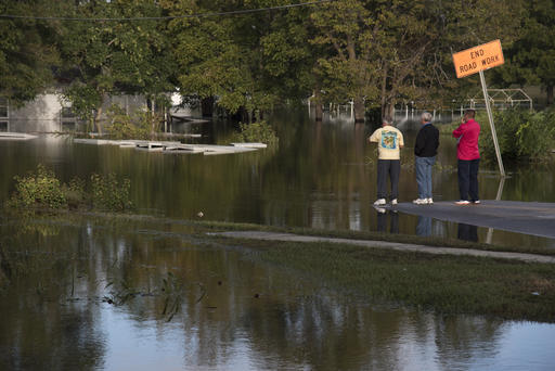 People look out towards West 5th Street that is covered by floodwaters caused by rain from Hurricane in Lumberton