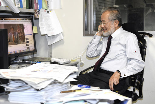 Japanese scientist Yoshinori Ohsumi answers a phone call following a news that he won this year's Nobel Prize in medicine at his office in the Tokyo Institute of Technology campus in Yokohama