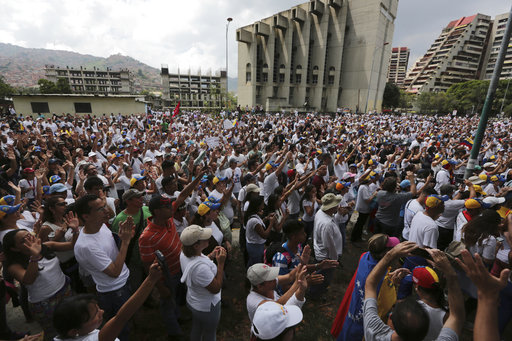 People gather for a silent protest outside the Venezuelan Episcopal Conference in homage to the at least 20 people killed in unrest generated after the nation's Supreme Court stripped congress of its last powers