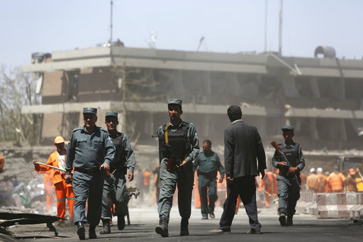 Security forces inspect the site of a suicide attack in front of German Embassy in Kabul