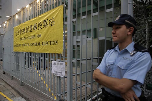 A police officer stands outside a polling station for the legislative council election Sunday