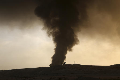 Smoke rises as people flee their homes during clashes between Iraqi security forces and members of the Islamic State group fleeing Mosul