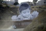 HOLD FOR STORY A Border Patrol vehicle drives in front of a mural in Tecate
