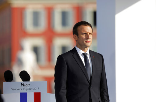French President Emmanuel Macron stands at attention during a ceremony in Nice