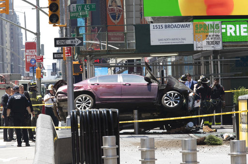 A car rests on a security barrier in New York's Times Square after driving through a crowd of pedestrians