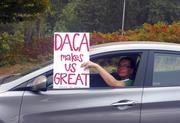 An unidentified woman holds a sign out her window as she drives through rush hour traffic in Portland