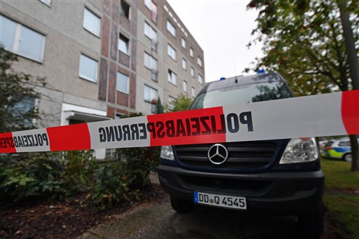 A police barrier tape and a vehicle of a forensic team blocks off the entrance to an apartment in the Paunsdorf district of Leipzig
