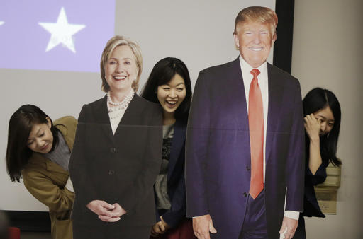 Guests pose for a photo with life-sized cutouts of Democratic presidential nominee Hillary Clinton and Republican presidential nominee Donald Trump prior to a public viewing of the U.S. presidential election debate between Clinton and Trump at the U.S. Embassy in Tokyo