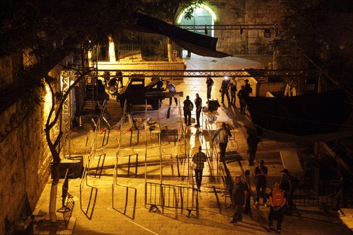 Israeli police officers dismantle metal detectors outside the Al Aqsa Mosque compound in Jerusalem's Old City