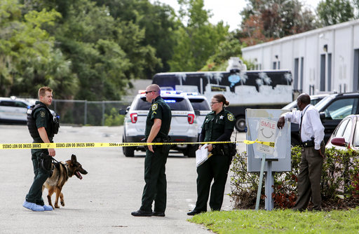 Law enforcement personnel investigate the scene where the scene where multiple people were killed in a shooting at a business in Orlando