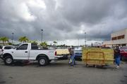 Men load recently purchased wood panels to be used for boarding up windows in preparation for Hurricane Irma
