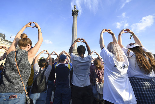 People gesture as they attend a vigil in Trafalgar Square