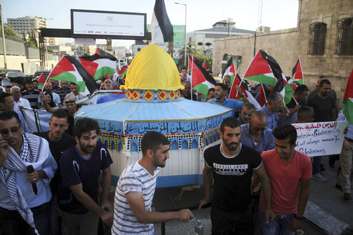 Palestinians carry a model of the Al Aqsa Mosque compound during a protest against the metal detectors placed at the entrance to mosque