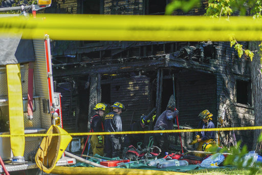 Firefighters investigate the remains of a burned home in Akron