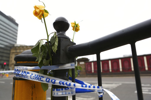 Flowers are attached to a railing close to Victoria Railway Station in Manchester