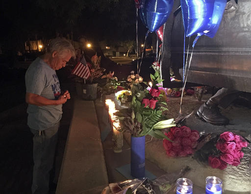 A citizen lights candles at a memorial for two slain police officers in Palm Springs