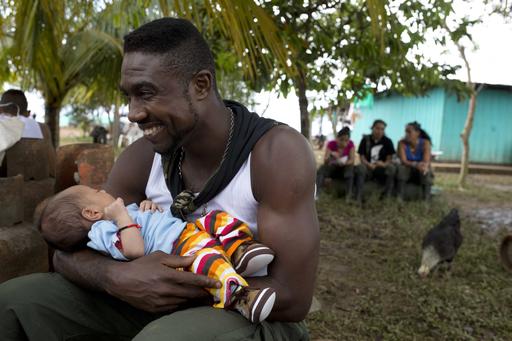 Diomedes holds the baby of a visiting relative of a fellow rebel of the Revolutionary Armed Forces of Colombia
