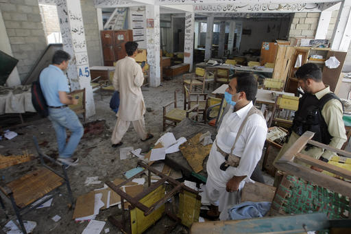 Pakistani officials examine a site of bombing in Mardan