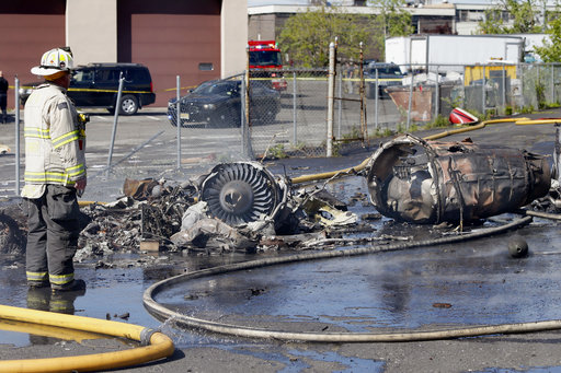 A firefighter stands looks over the scene after a jet crashed into a building near Teterboro Airport in Carlstadt