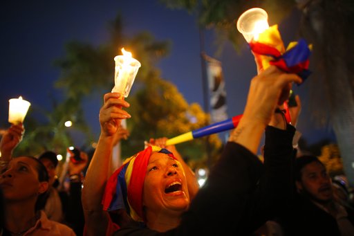 Demonstrators hold candles during a vigil for the victims of the clashes with the government's security forces